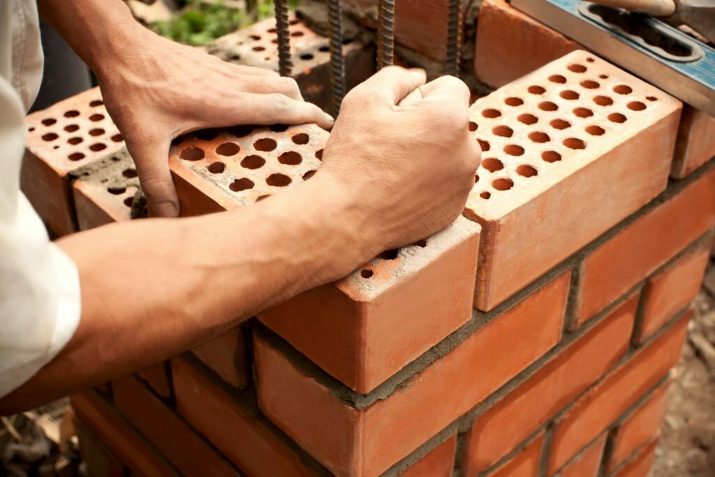 worker hands on bricks